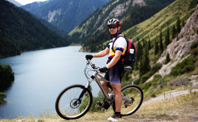 Biker beside mountain lake